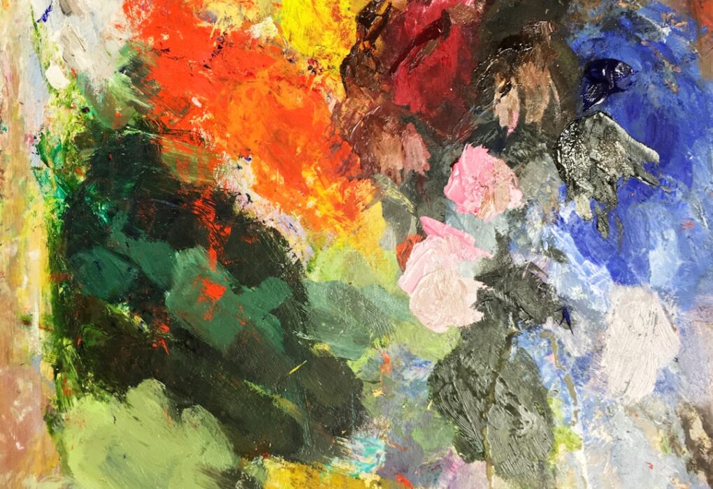 Paleta de artista com respingos de tinta em várias cores misturadas