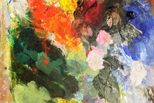 Paleta de artista com respingos de tinta em várias cores misturadas