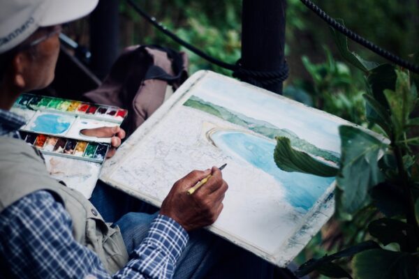 Pessoa pintando com aquarela, pincel e água