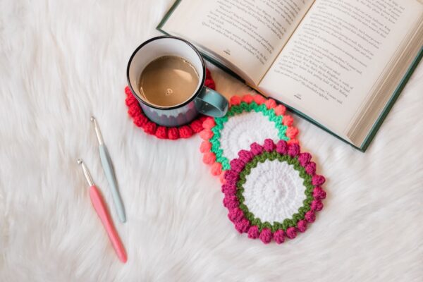 Porta-copo de crochê feito à mão sobre a mesa com xícara de café